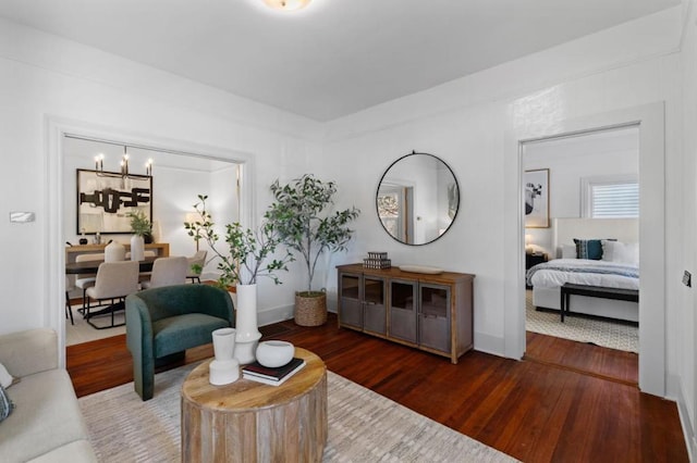 living room with dark hardwood / wood-style floors and a chandelier