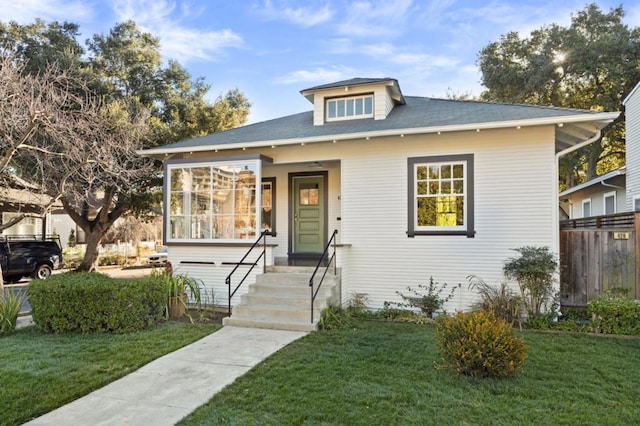 bungalow-style home with a sunroom and a front lawn