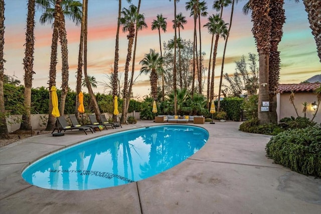 pool at dusk with a patio