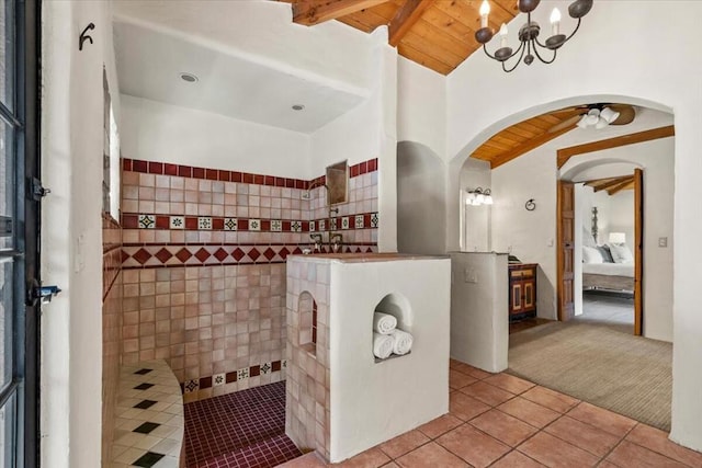 bathroom with wood ceiling, tile patterned flooring, lofted ceiling with beams, ceiling fan, and a tile shower