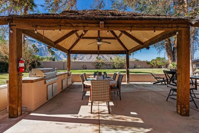 view of patio / terrace with ceiling fan, a gazebo, exterior kitchen, and area for grilling