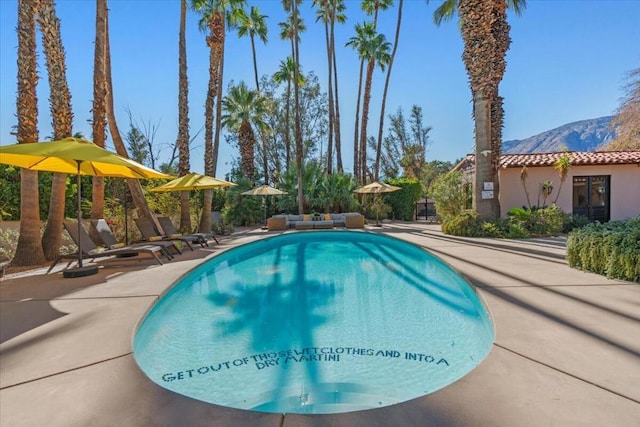 view of swimming pool with a mountain view and a patio