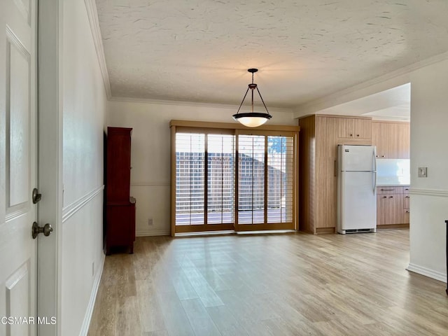 interior space featuring crown molding, light hardwood / wood-style flooring, and a textured ceiling