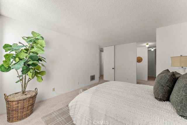 bedroom featuring light carpet and a textured ceiling