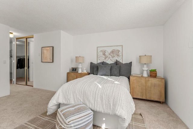 carpeted bedroom with a textured ceiling and a closet