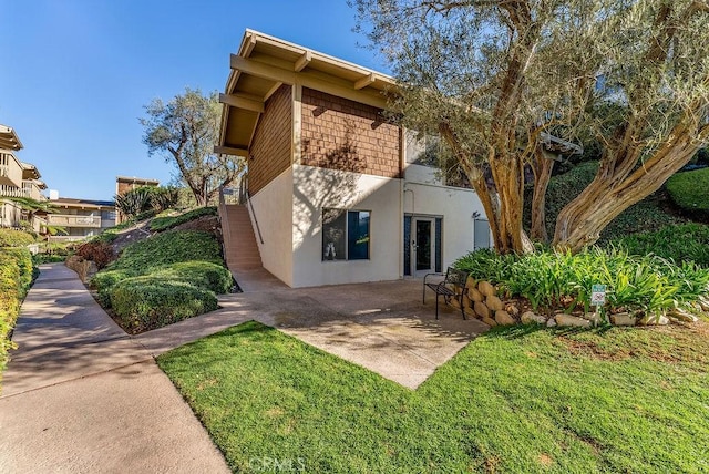 rear view of house with a yard and a patio