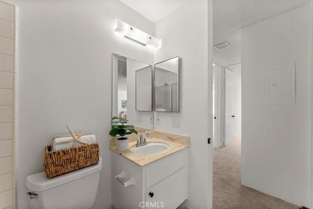 bathroom featuring a textured ceiling, toilet, and vanity