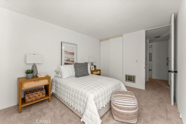 bedroom with a textured ceiling, heating unit, and carpet floors