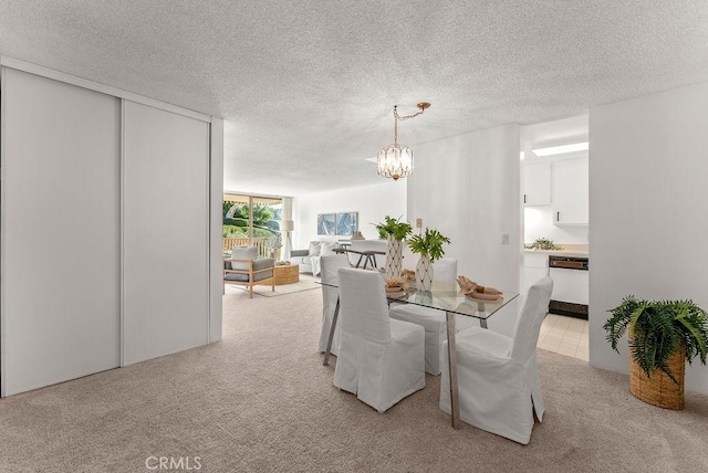 dining space featuring light carpet, an inviting chandelier, and a textured ceiling