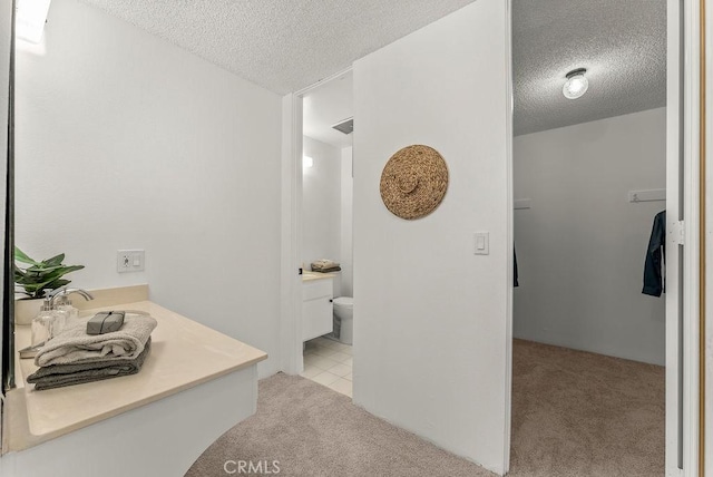 bathroom with toilet, a textured ceiling, and vanity