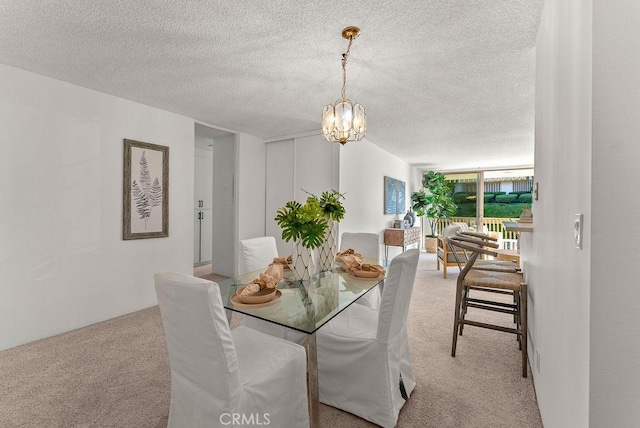 dining area with a textured ceiling, light colored carpet, and a notable chandelier