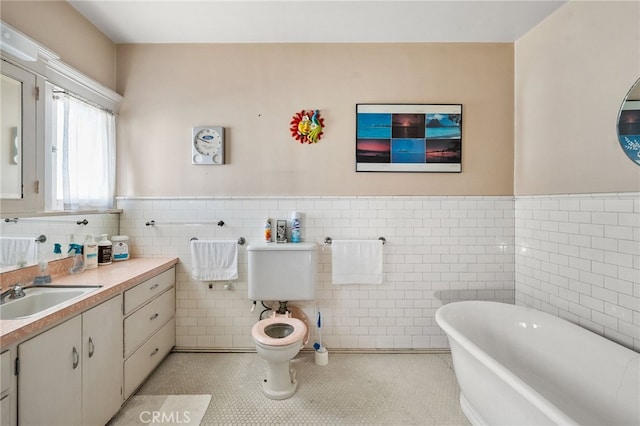 bathroom with tile patterned flooring, a bathtub, tile walls, and vanity