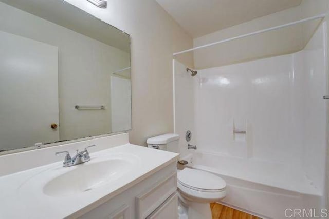 full bathroom with toilet, wood-type flooring, vanity, and bathing tub / shower combination