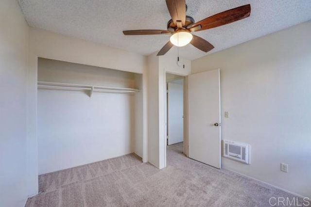 unfurnished bedroom featuring a textured ceiling, ceiling fan, a closet, and light carpet