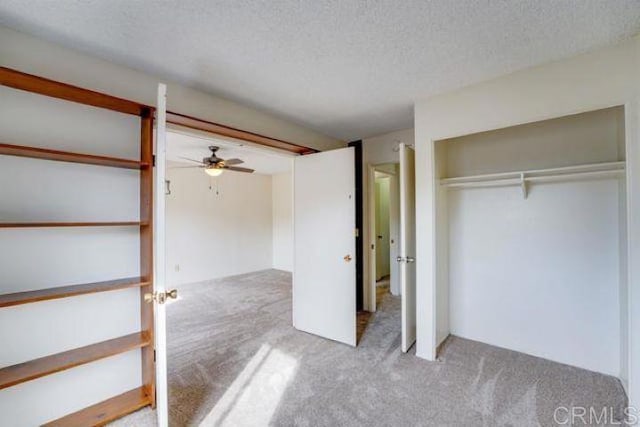 unfurnished bedroom featuring a closet, a textured ceiling, ceiling fan, and light colored carpet