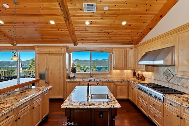 kitchen featuring wall chimney range hood, sink, lofted ceiling with beams, stainless steel gas cooktop, and a mountain view