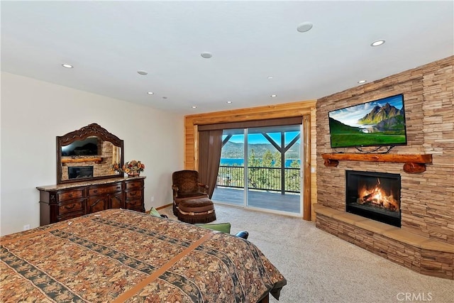 bedroom with carpet floors, access to outside, and a stone fireplace