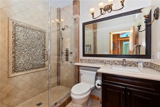 bathroom with vanity, toilet, backsplash, and a shower with door