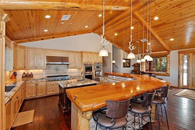 kitchen with wooden ceiling, hanging light fixtures, a center island with sink, and extractor fan