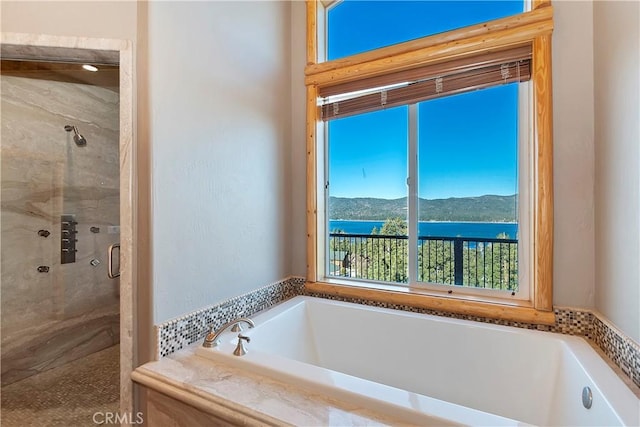 bathroom featuring a water and mountain view and independent shower and bath