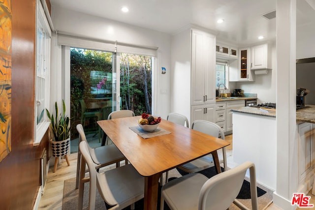 dining space with light hardwood / wood-style flooring and sink