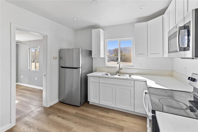 kitchen with white cabinets, appliances with stainless steel finishes, and sink