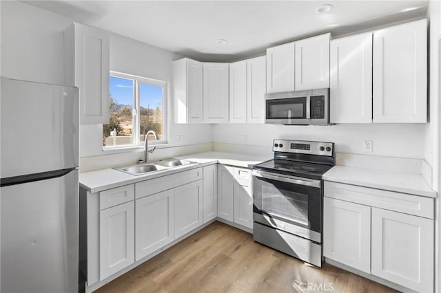 kitchen featuring light hardwood / wood-style floors, sink, white cabinetry, and stainless steel appliances