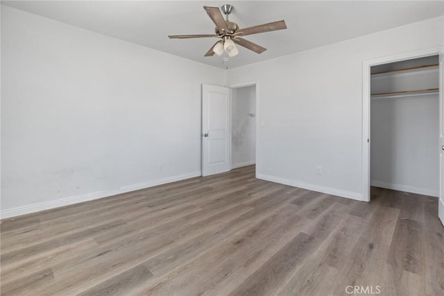 unfurnished bedroom featuring ceiling fan, a closet, and light hardwood / wood-style flooring