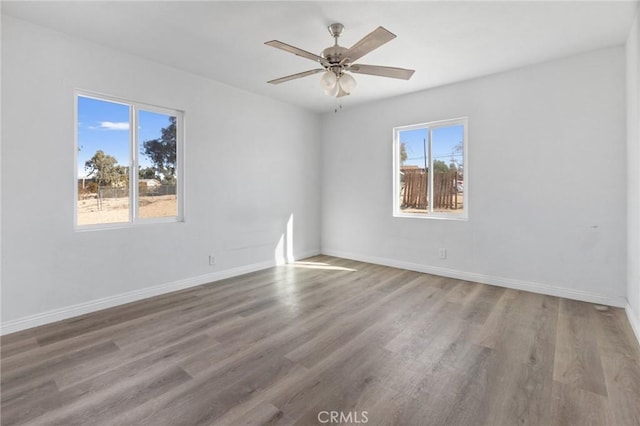 spare room featuring ceiling fan, plenty of natural light, and wood-type flooring