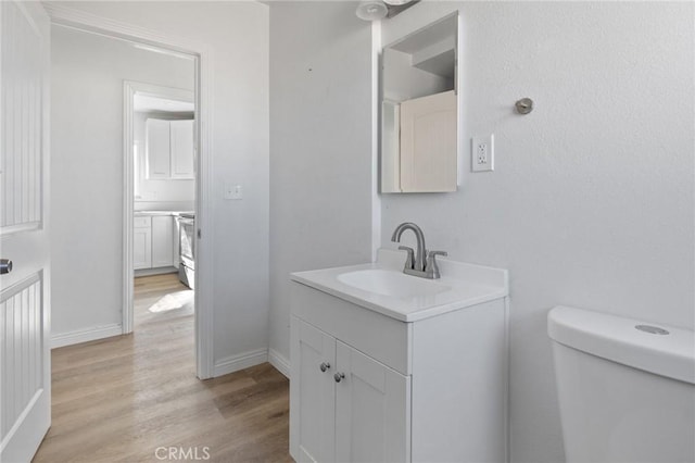 bathroom featuring toilet, vanity, and wood-type flooring