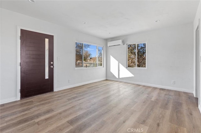 foyer featuring an AC wall unit and light hardwood / wood-style floors