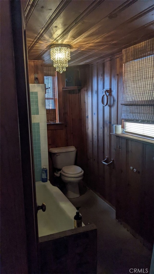 bathroom with toilet, wooden ceiling, wood walls, and a notable chandelier