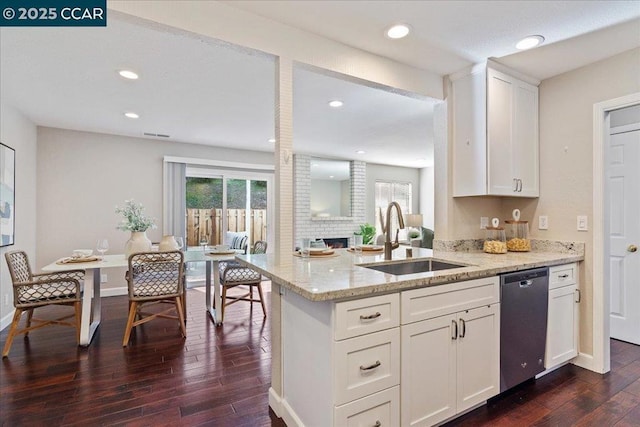 kitchen featuring stainless steel dishwasher, sink, white cabinets, light stone counters, and dark hardwood / wood-style floors