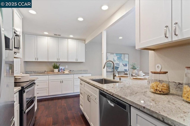 kitchen with dark wood-type flooring, white cabinetry, stainless steel appliances, sink, and light stone counters