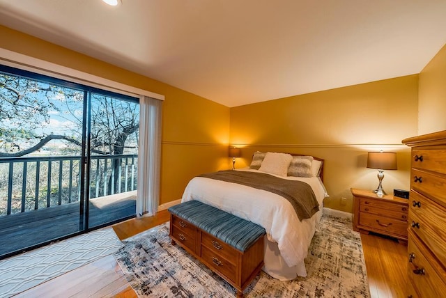 bedroom featuring access to exterior and light wood-type flooring