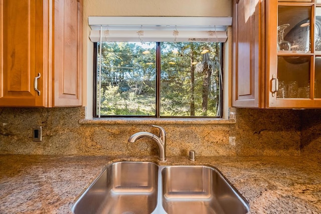 kitchen with a healthy amount of sunlight, sink, and light stone counters