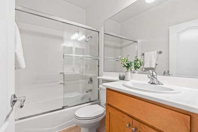 full bathroom featuring toilet, bath / shower combo with glass door, tile patterned floors, and vanity