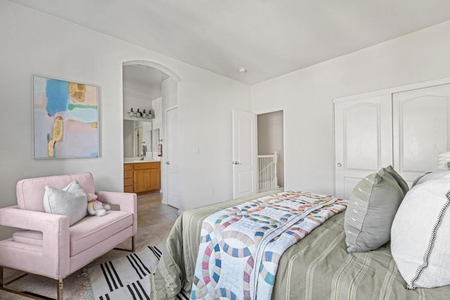 carpeted bedroom with a closet and ensuite bath