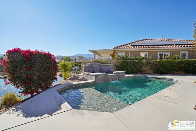 view of swimming pool featuring pool water feature and a mountain view