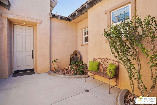 view of exterior entry featuring a patio area