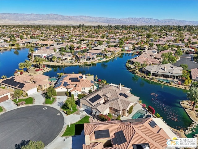 birds eye view of property with a water and mountain view