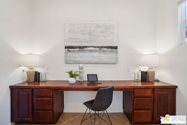 office space featuring light tile patterned flooring and built in desk