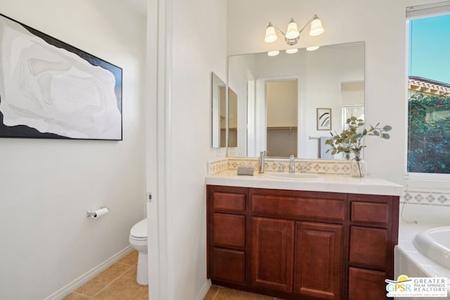 bathroom featuring vanity, tile patterned floors, tiled bath, and toilet