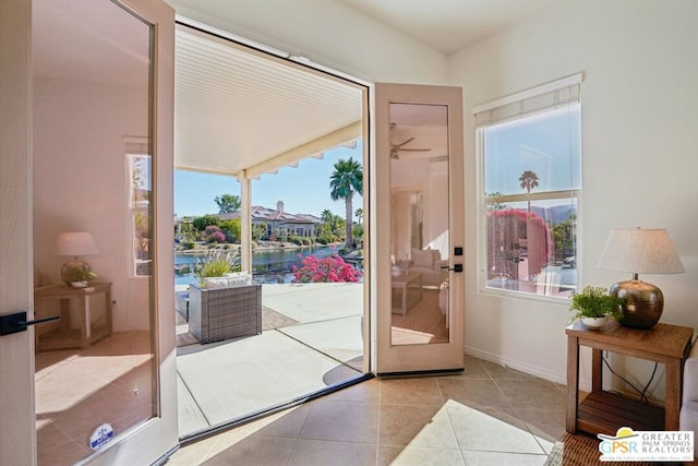 doorway to outside featuring light tile patterned flooring and a water view