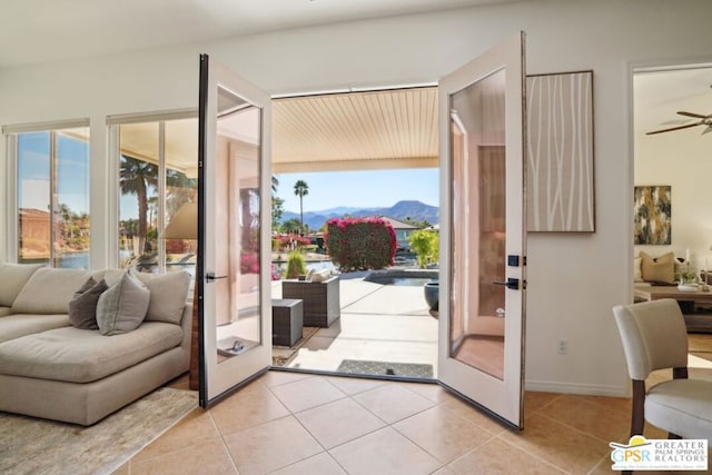 entryway with french doors, a mountain view, and light tile patterned floors