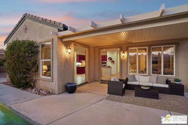 patio terrace at dusk featuring an outdoor hangout area