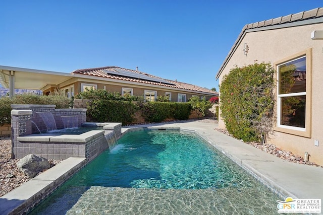 view of swimming pool with a jacuzzi and pool water feature