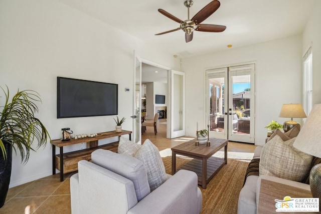 tiled living room featuring french doors and ceiling fan