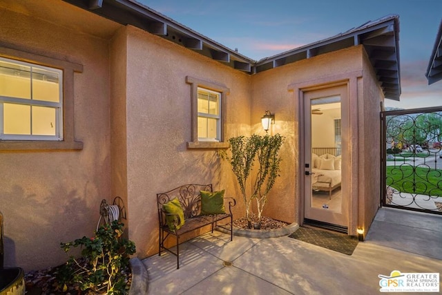 exterior entry at dusk featuring a patio area