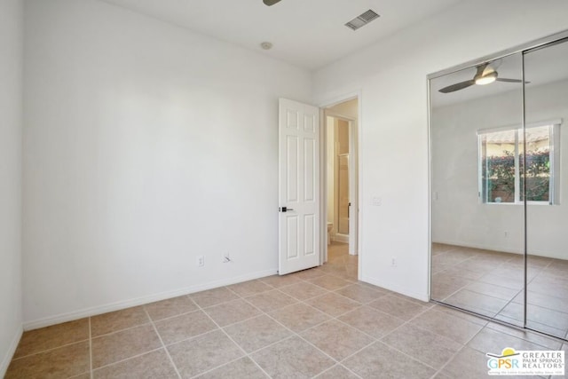 unfurnished bedroom with ceiling fan, a closet, and light tile patterned floors